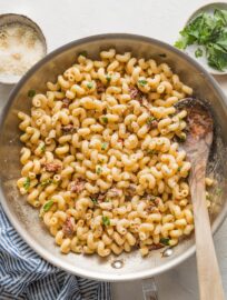 Skillet filled with a creamy cavatappi pasta with Parmesan and sun-dried tomatoes.