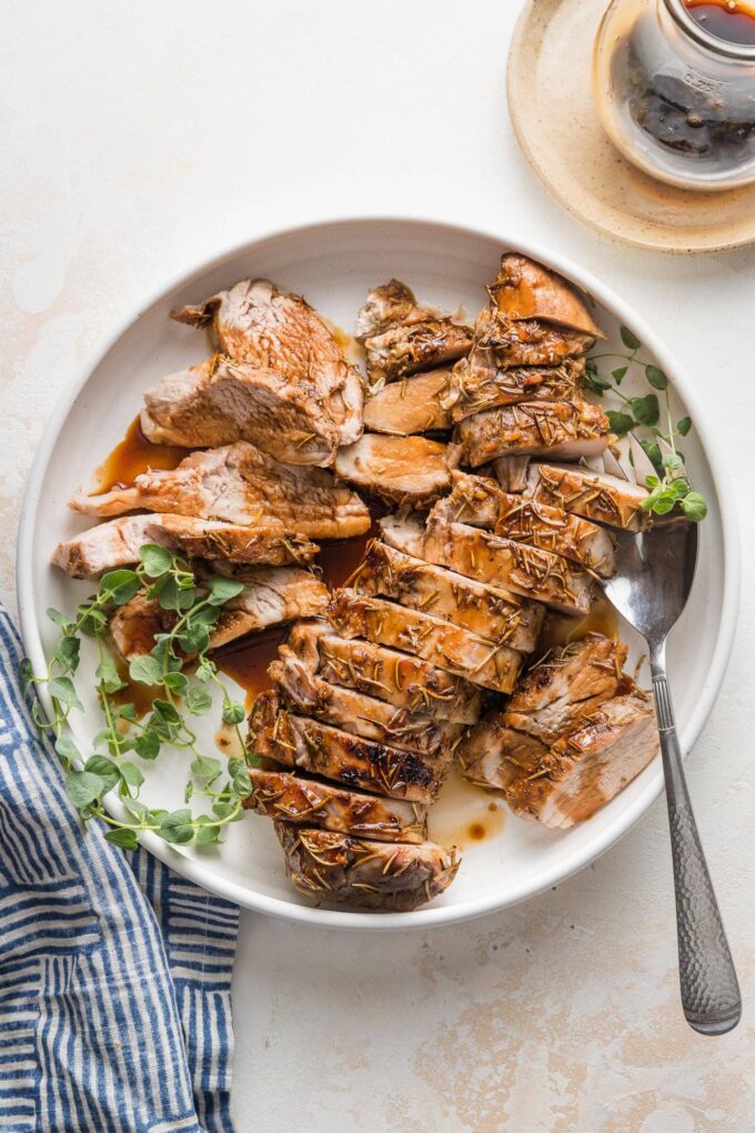Platter with sliced pork tenderloin and a serving fork.