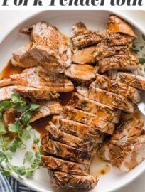 Pork tenderloin cooked with a balsamic glaze, sliced into medallions, and presented on a platter with a garnish of fresh oregano.