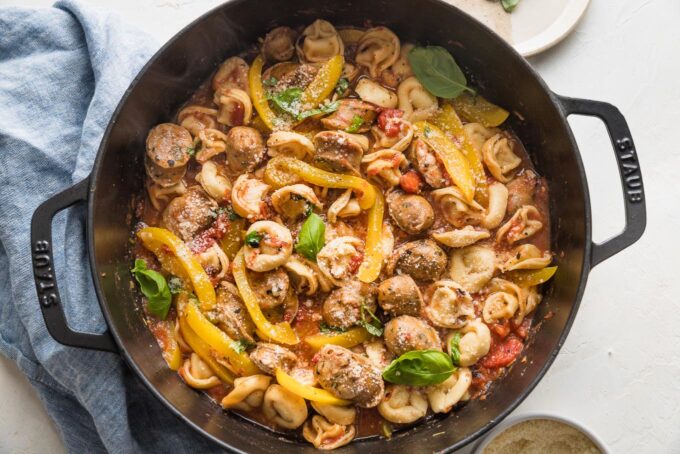 Tortellini cooked in skillet with broth, tomatoes, sausage, and peppers.