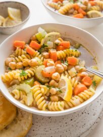 Side angle view of a bowl full of vegetarian chickpea noodle soup.