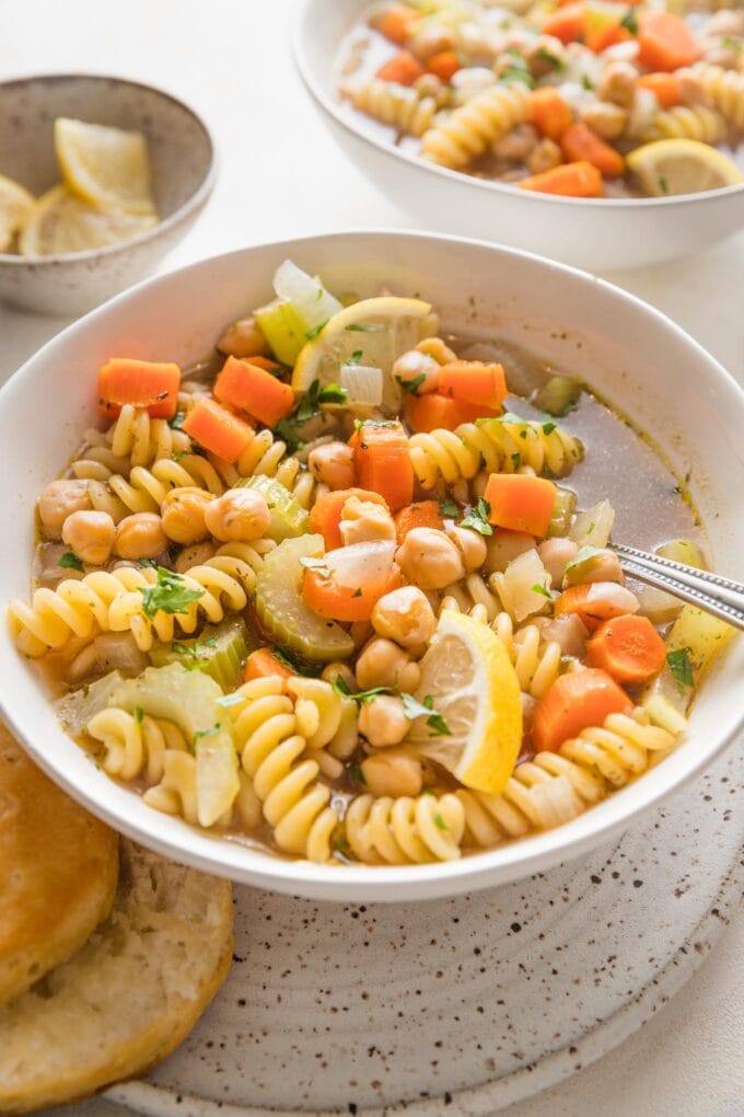 Side angle view of a bowl full of vegetarian chickpea noodle soup.