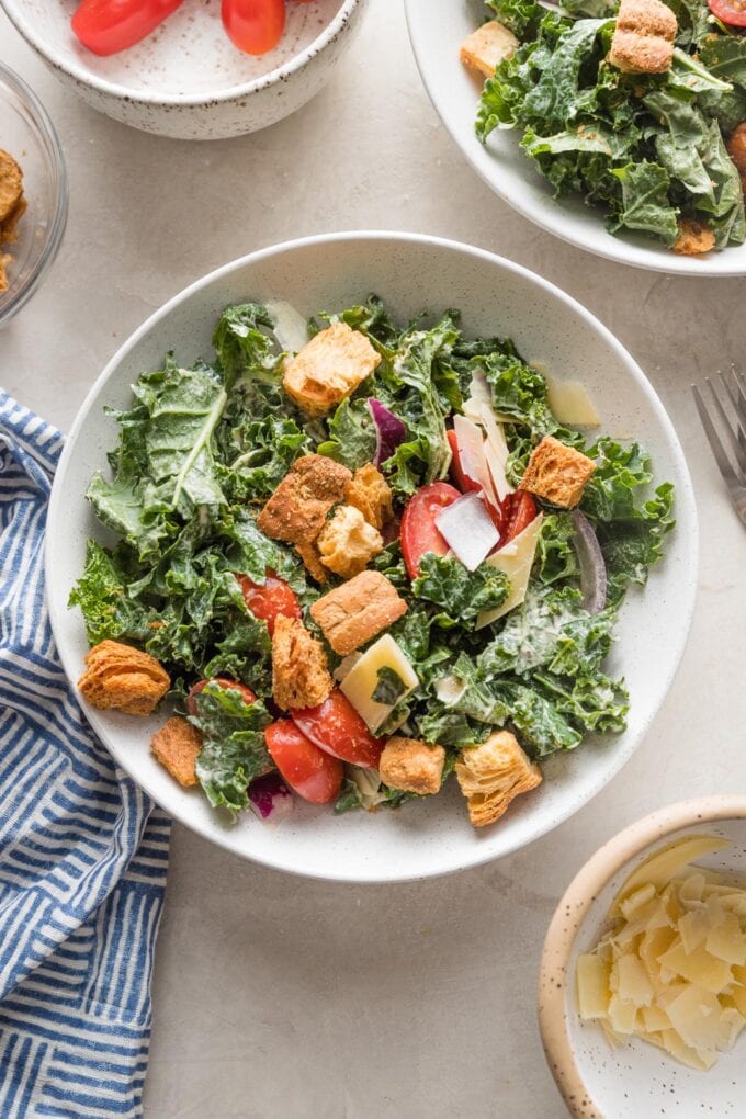 Low bowl plated with Caesar kale salad, waiting for protein to be added on.