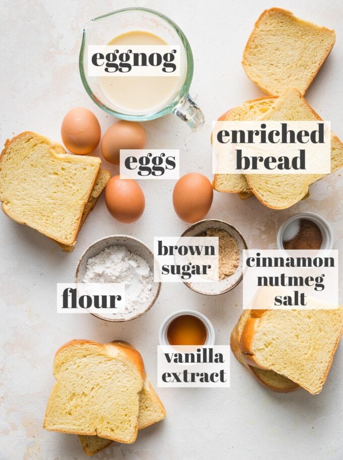 Labeled overhead photo of thick cut enriched bread slices, eggnog, eggs, flour, brown sugar, vanilla, and spices in prep bowls.