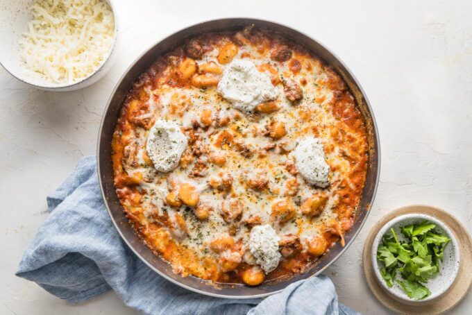 Ground beef baked gnocchi just out of the oven with extra dollops of ricotta cheese on top.