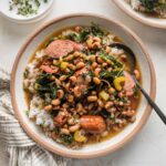 Shallow bowl filled with rice and a stew-like black eyed peas recipe.