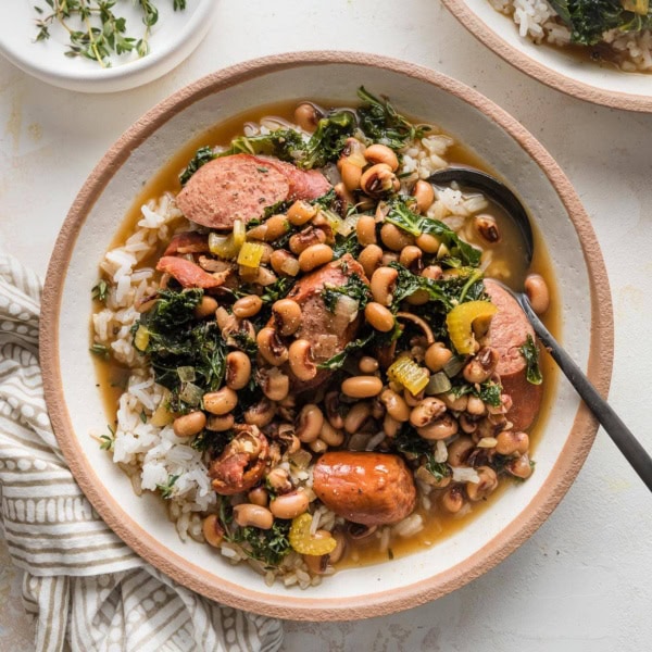 Shallow bowl filled with rice and a stew-like black eyed peas recipe.