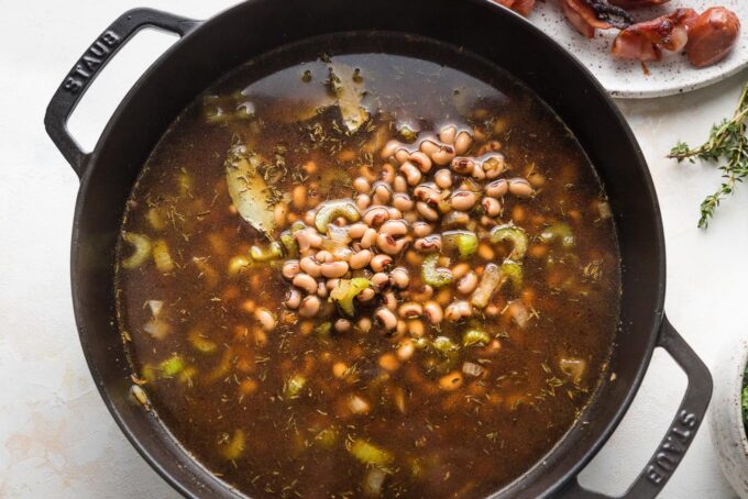 Broth and black eyed peas added to deep skillet with aromatics.
