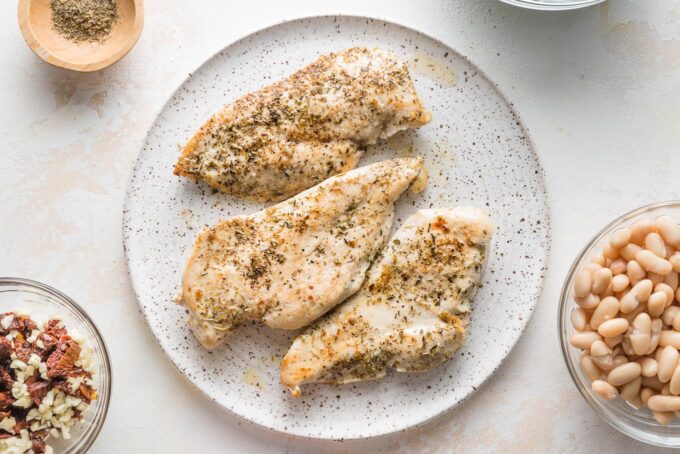 Seared chicken breasts resting on a plate.