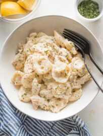 Small white bowl holding a big portion of creamy, cheesy chicken tortellini Alfredo.