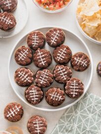 Platter of football cupcakes served for a tailgate party with chips, salsa, and frosty cold beer.