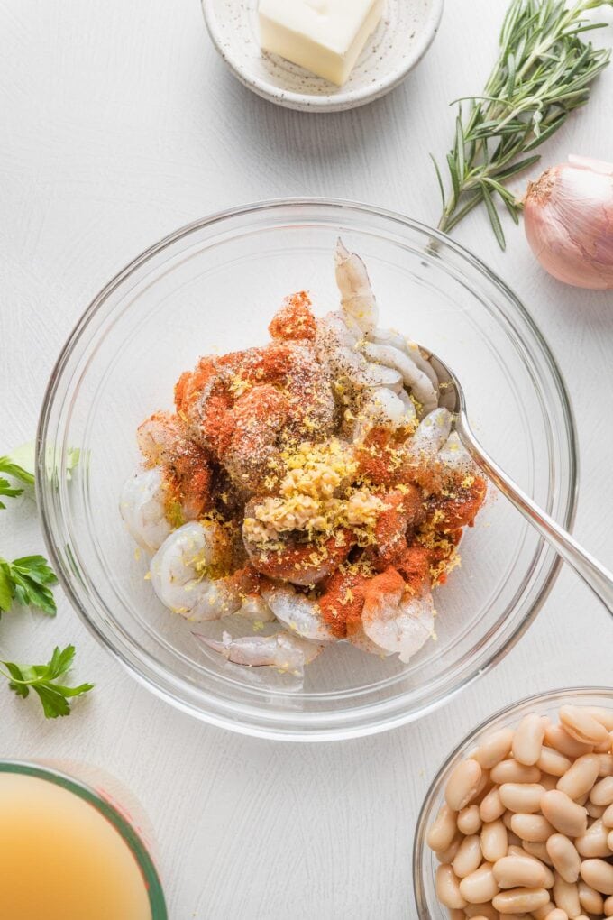 Shrimp with seasonings in a prep bowl.