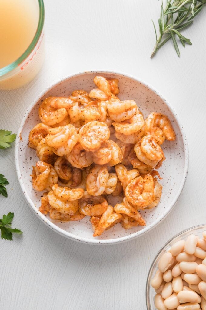 Cooked shrimp set aside in a small bowl.