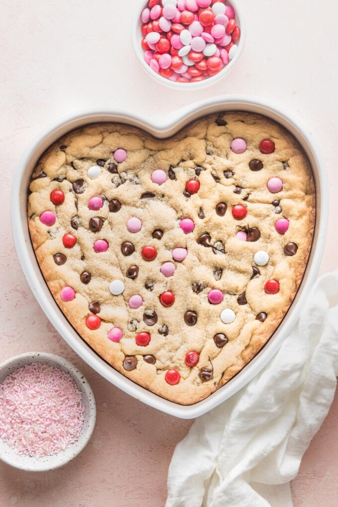 Valentine's heart-shaped cookie cake just taken out of the oven, with a golden brown, just set top, and slightly puffy edges.