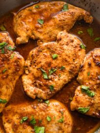 Close up of a chicken breast pan fried with Cajun seasoning and butter sauce.