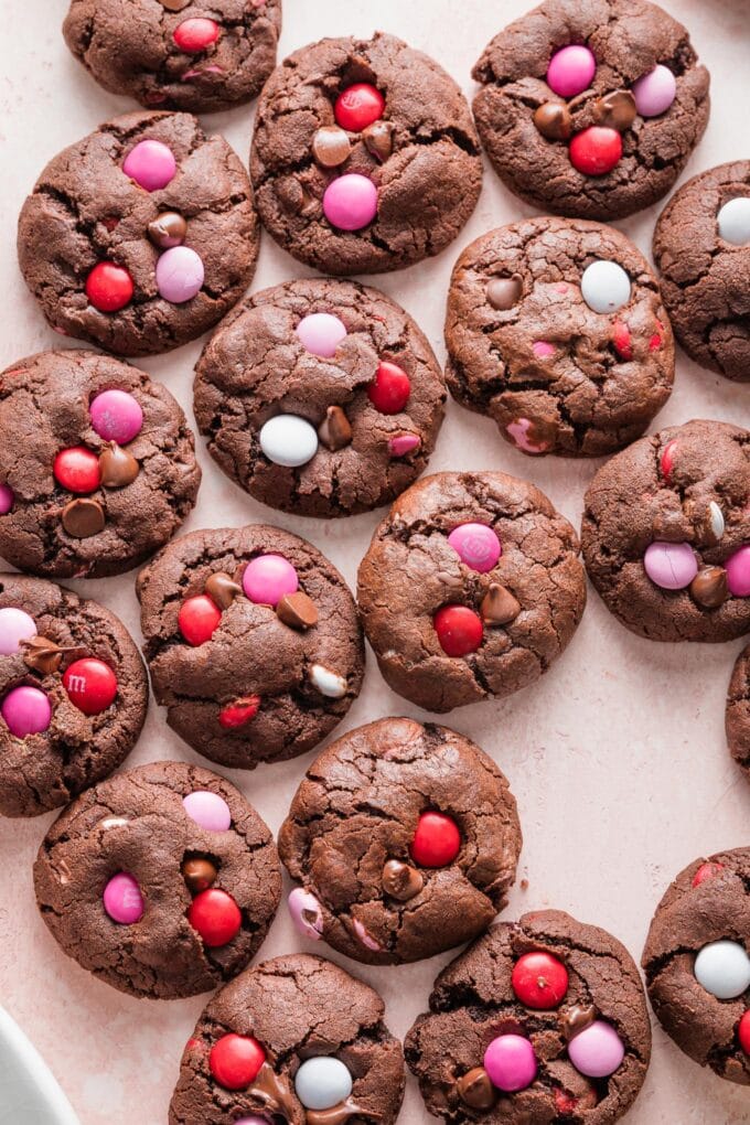 Pink countertop filled with rows of double chocolate Valentines cookies.