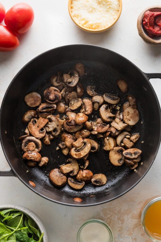 Mushrooms and garlic sauteed to a deep brown in a cast iron skillet.