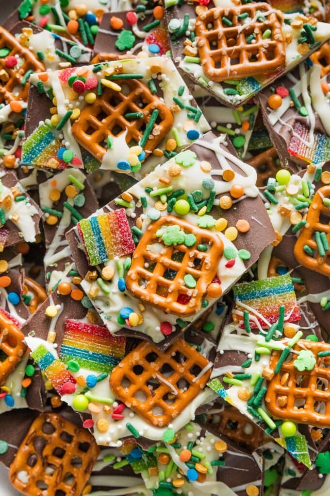 Close up of a piece of chocolate leprechaun bark with pretzels, sprinkles, and tart rainbow sours.