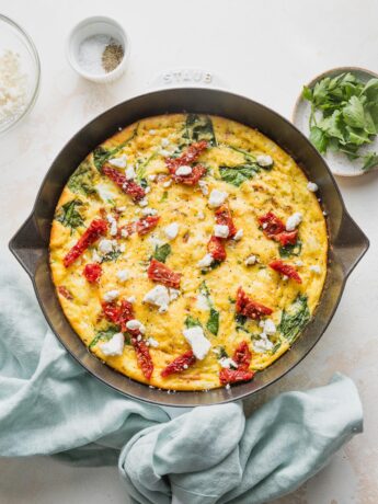 Overhead view of a Mediterranean frittata in a small cast iron skillet.