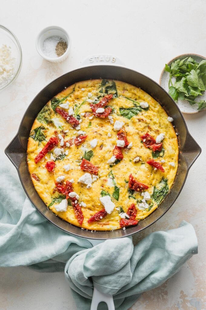 Overhead view of a Mediterranean frittata in a small cast iron skillet.