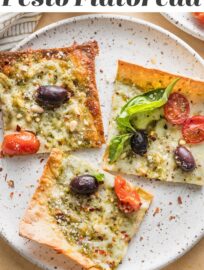 Crazy easy and packed with flavor, this Pesto Flatbread pizza has lots to love! We devour the fresh basil pesto, briny Kalamata olives, juicy tomatoes, and creamy mozzarella and Parmesan. And who doesn't enjoy a satisfying meal that takes just 5 minutes to toss together and 10 minutes to bake?