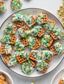 Black-rimmed white plate full of St. Patrick's Day Rolo pretzel candies.