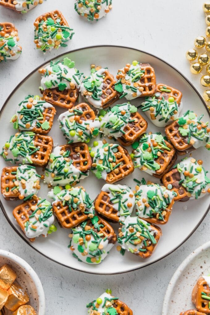 Black-rimmed white plate full of St. Patrick's Day Rolo pretzel candies.