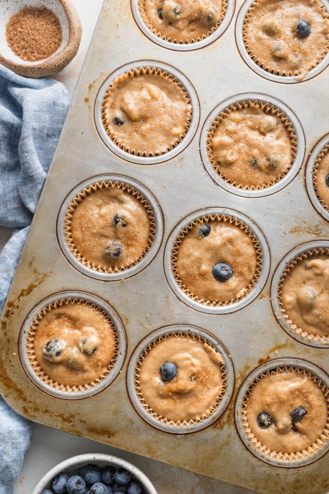 Muffin tin filled with batter for banana blueberry muffins.