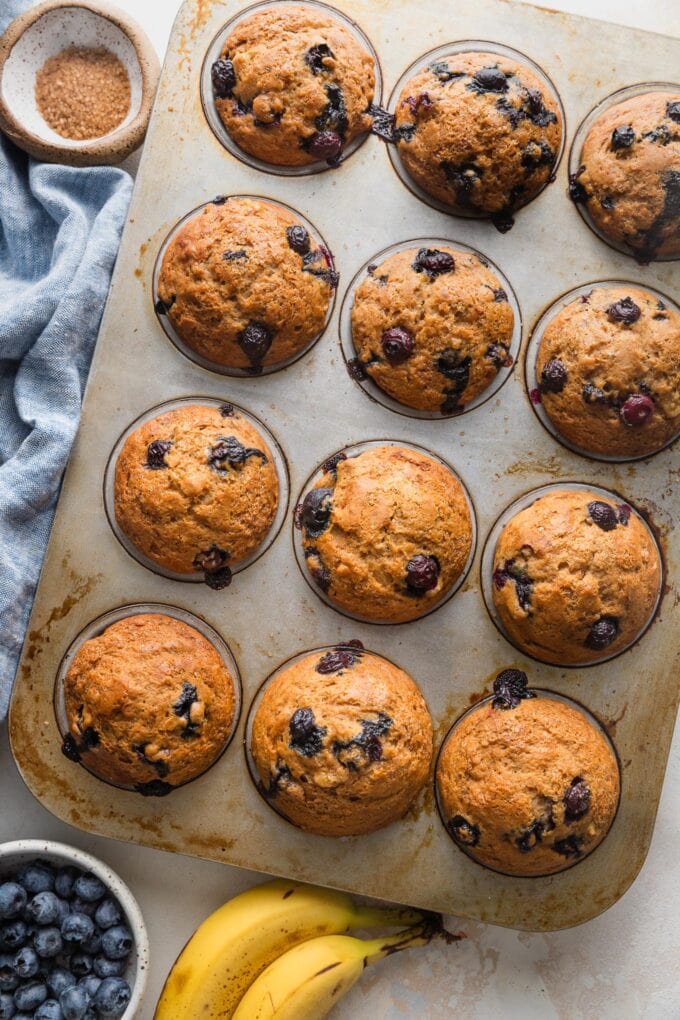 Just-baked banana blueberry muffins cooling briefly in the pan.