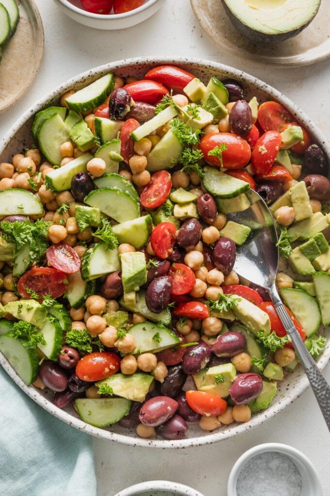 Overhead view of chickpea avocado salad in a large low bowl, ready to serve.