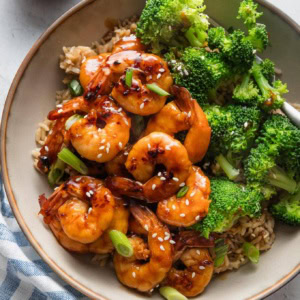 Low bowl full of honey garlic shrimp served with jasmine rice and steamed broccoli.