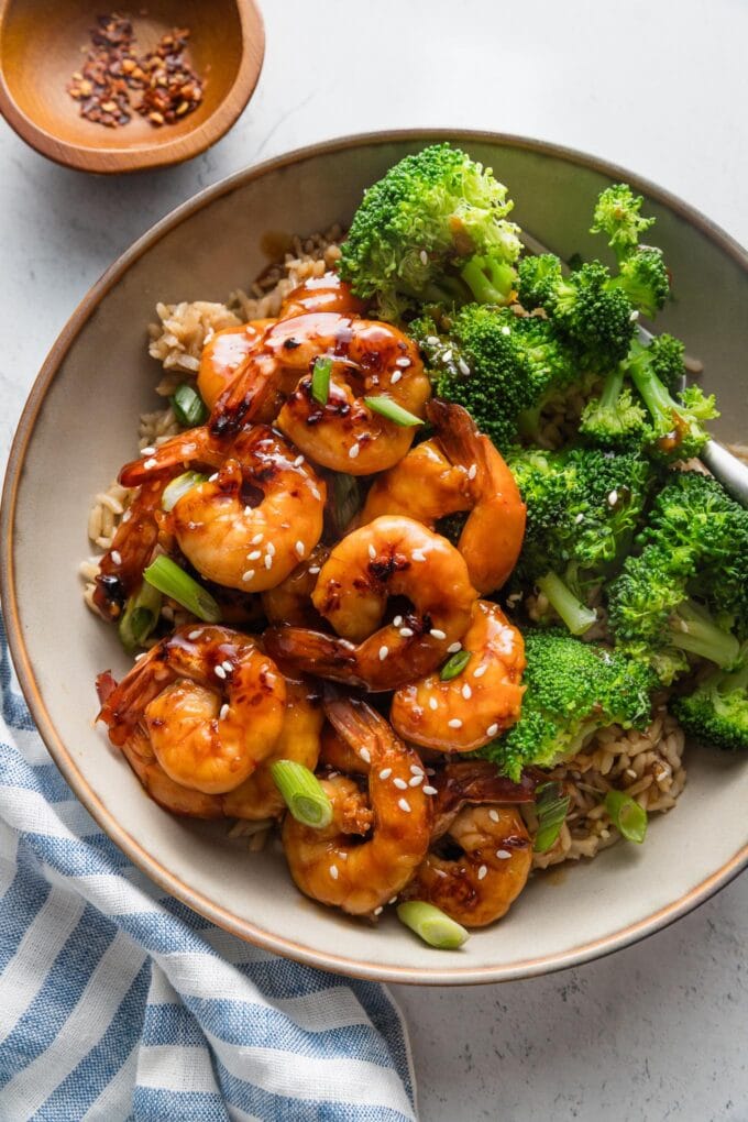 Low bowl full of honey garlic shrimp served with jasmine rice and steamed broccoli.