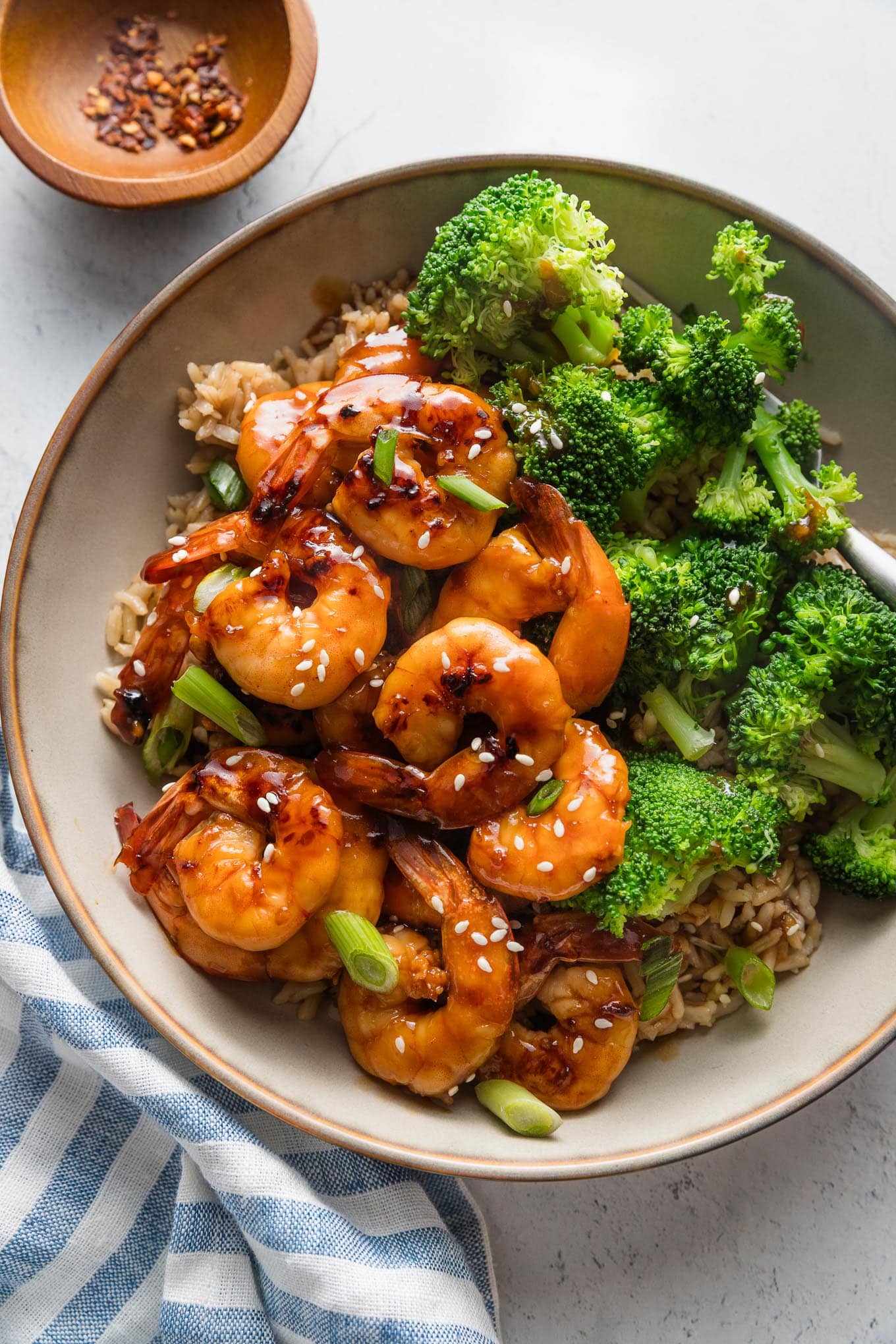 Low bowl full of honey garlic shrimp served with jasmine rice and steamed broccoli.