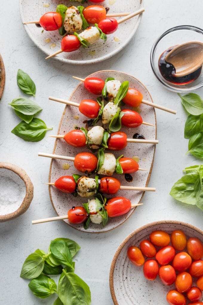 Small oval platter filled with Caprese skewers.