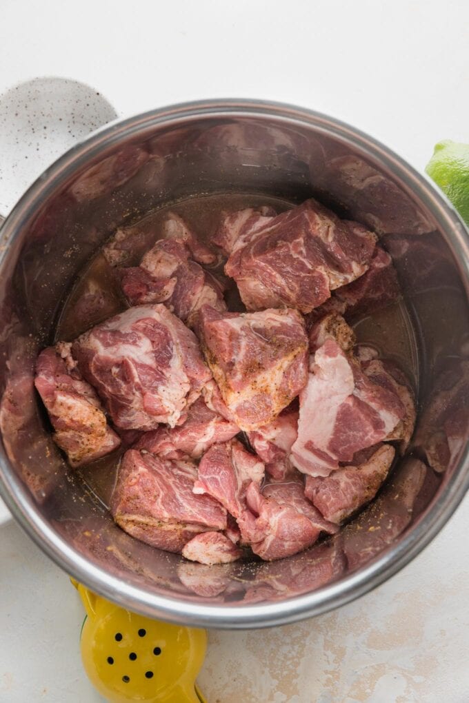 Spice rub rubbed into pork cubes in an Instant Pot insert.