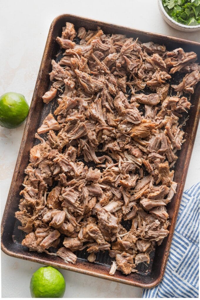 Shredded pork shoulder on a sheet pan.