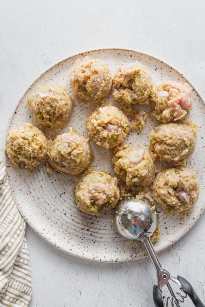 Cookie dough scoop being used to portion meatballs.