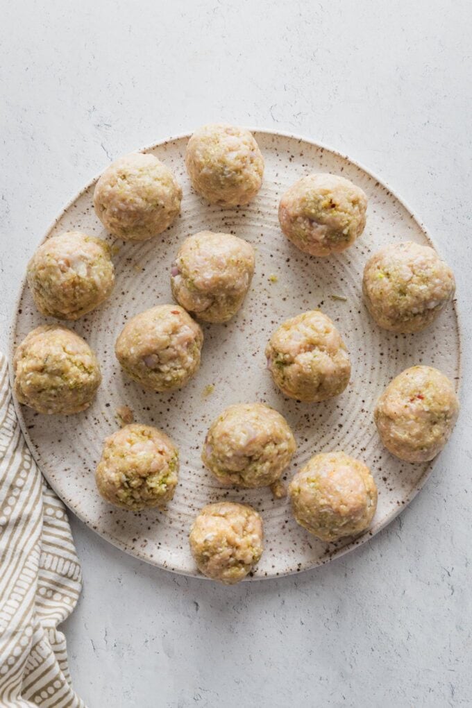 Smooth meatballs on a plate and ready to fry.
