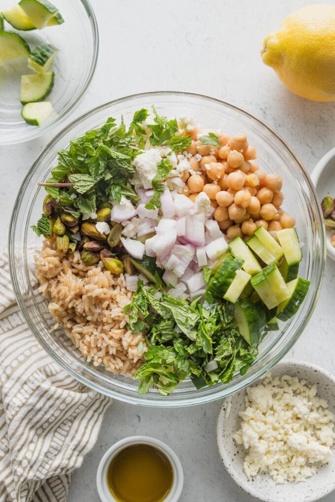 Glass bowl with Jennifer Aniston salad ingredients added in sections.