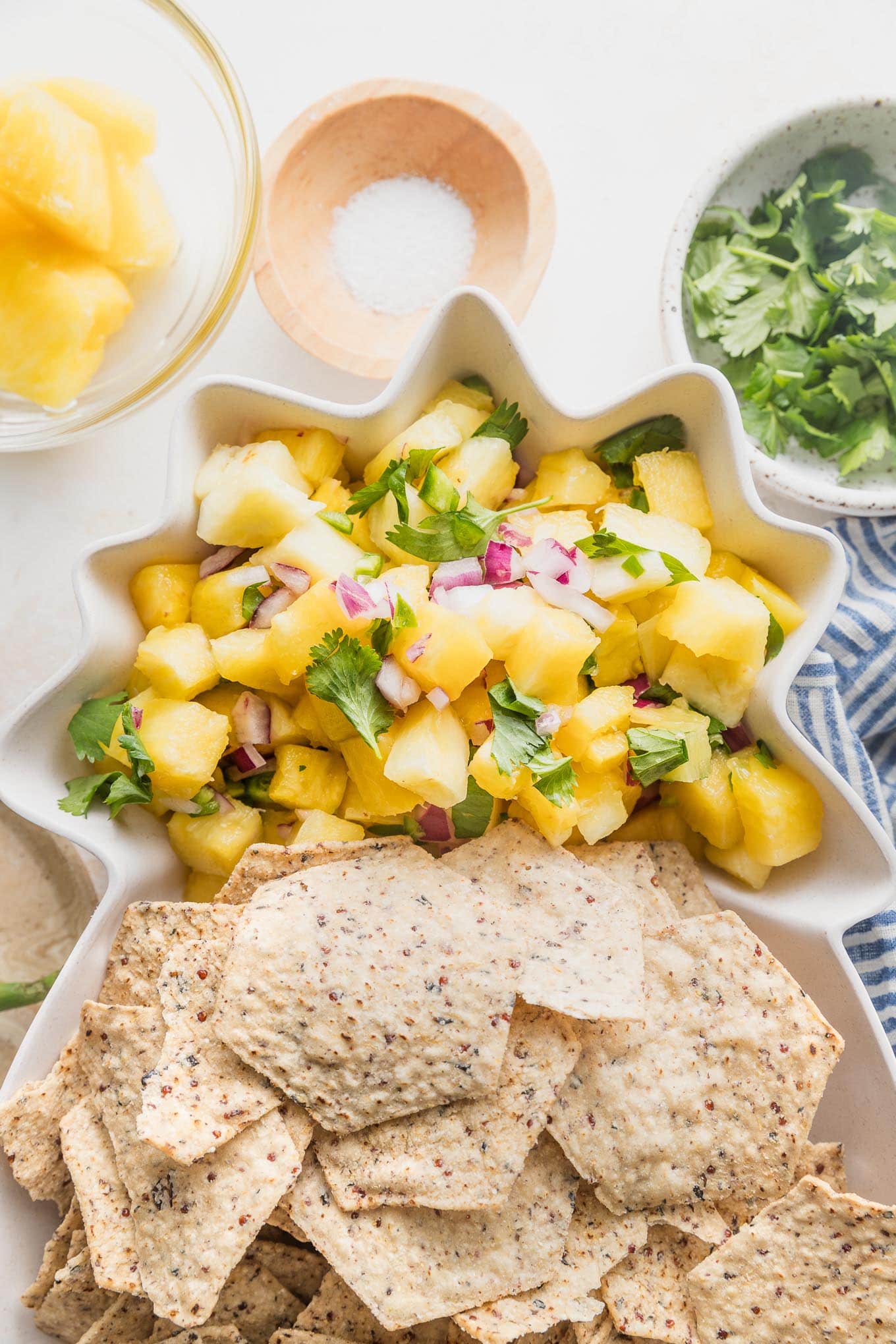 Pineapple salsa served with tortilla chips in a pineapple shaped serving dish.