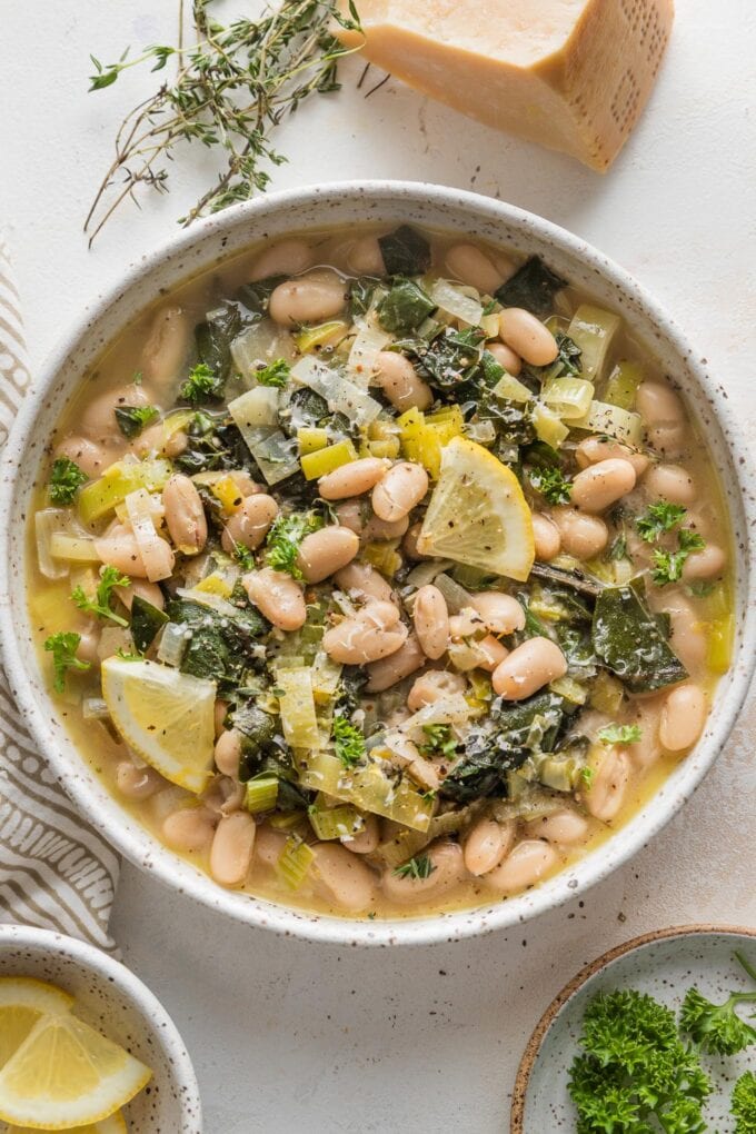 Low bowl filled with a Mediterranean-inspired beans and greens with Parmesan and Swiss chard.