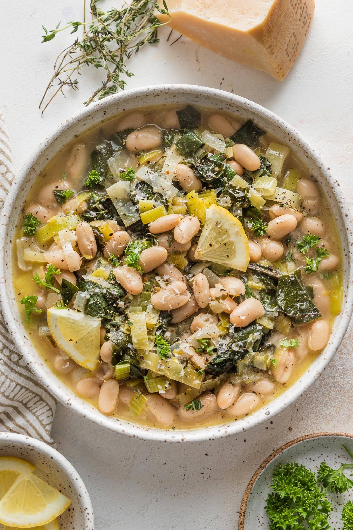 Low bowl filled with a Mediterranean-inspired beans and greens with Parmesan and Swiss chard.