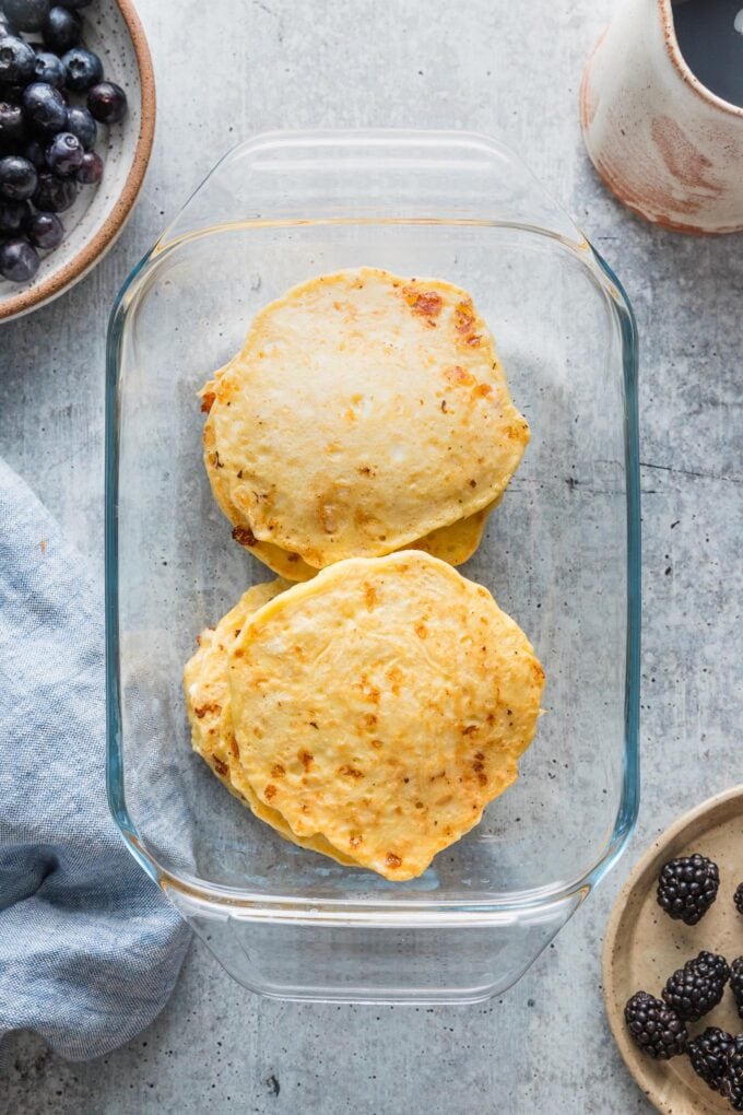 Small glass baking dish filled with cottage cheese pancakes to be kept warm in the oven.