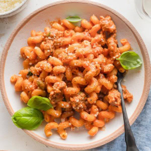 Overhead view of creamy tomato sausage pasta in a small serving bowl.