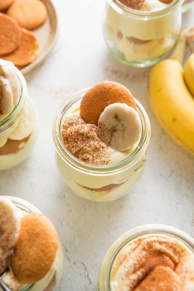 Close up of an individual portion of banana pudding with extra banana in the background.