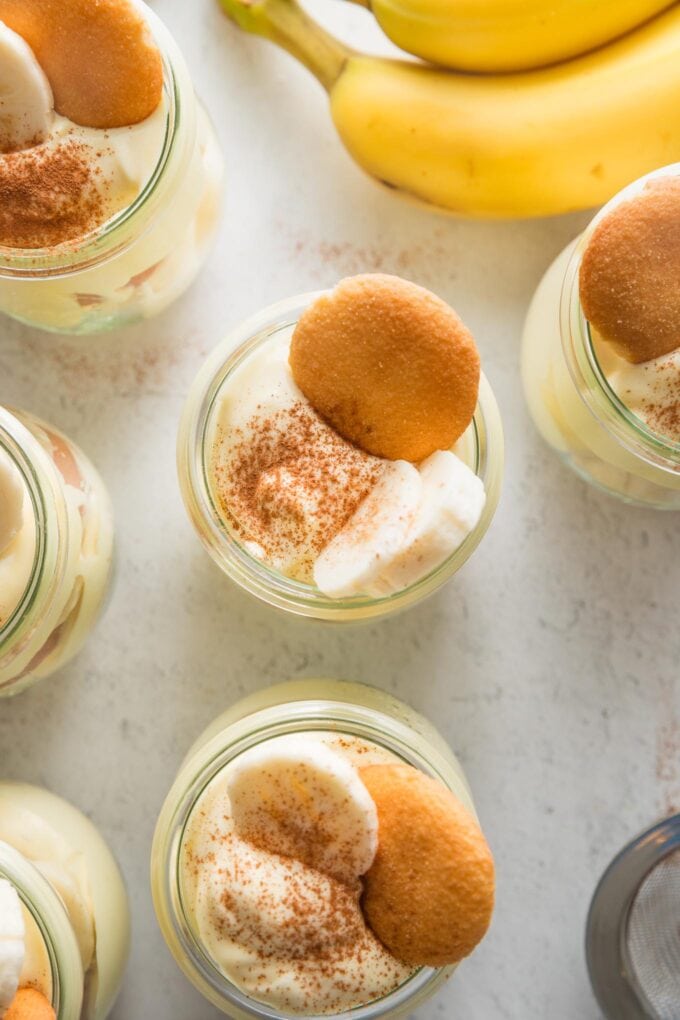Overhead view of individual banana puddings topped with banana slices and Nilla wafers.