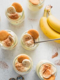 Countertop with six individual banana pudding parfaits ready to serve.
