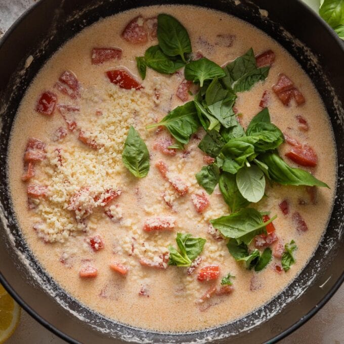 Basil and Parmesan added to cream sauce with tomatoes.