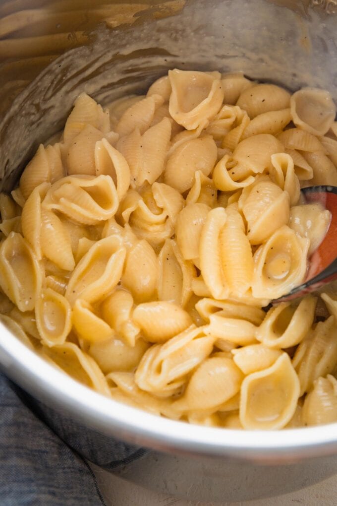 An Instant Pot insert filled with extra creamy mac and cheese made with small pasta shells.
