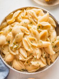 Close up of a spoon scooping out a portion of Instant Pot mac and cheese from a small serving bowl.